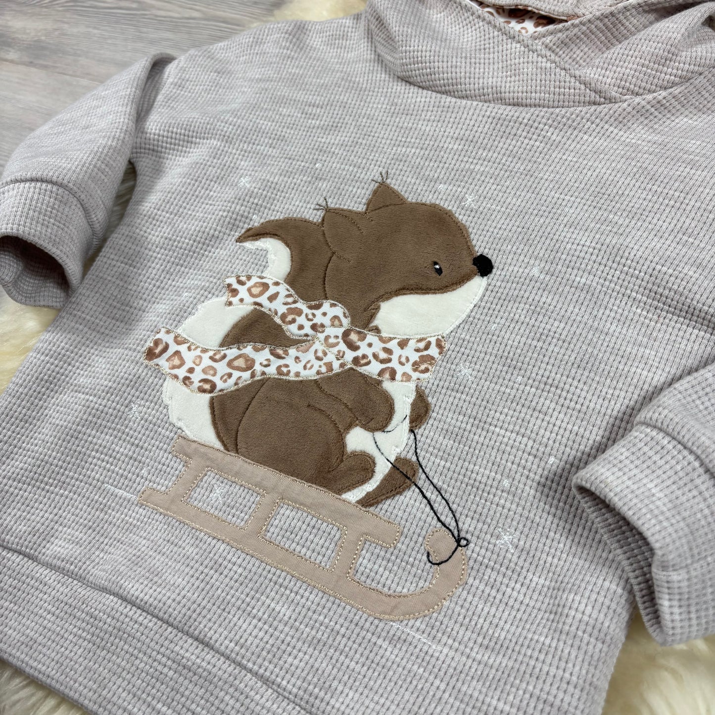 Hoodie mit Stickbild Eichhörnchen auf dem Schlitten